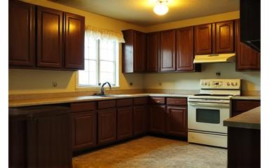 Before: Outdated kitchen with dark cabinets and linoleum floor